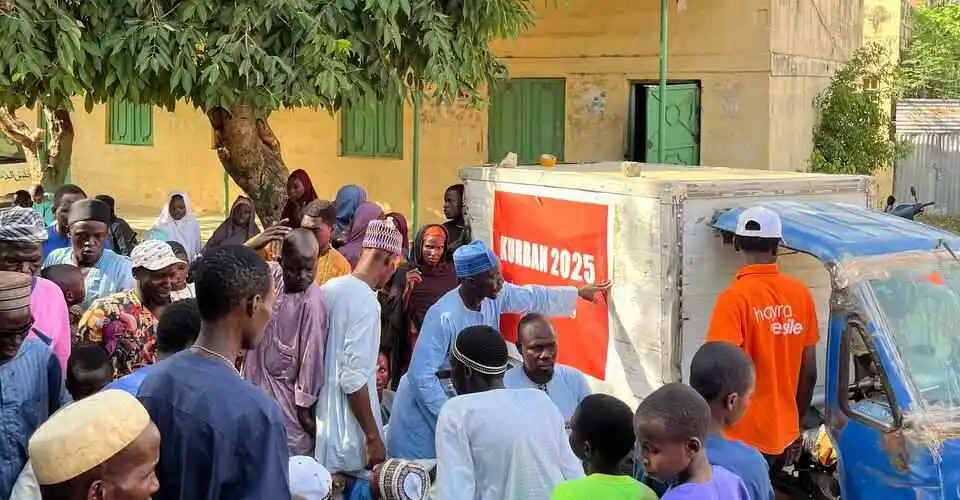 'Kurban Bayramı'nda Yapılabilecek Yardımlar Nelerdir?' başlığı için Hayra Vesile pankartı ve arabası önünde Afrikalı halka et yardımı