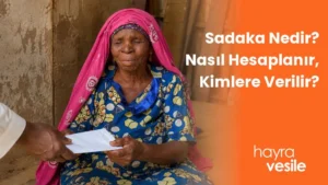 Afrikalı bir teyzeye sadaka yardımı için zarf uzatılması ve yanında 'Sadaka Nedir? Nasıl Hesaplanır ,Kimlere Verilir' başlığı